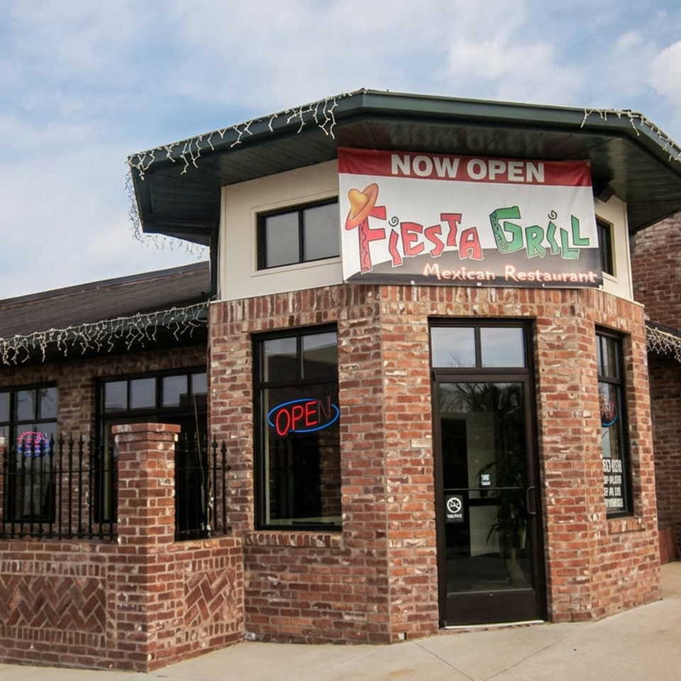 Brick storefront for Fiesta Grill Mexican Restaurant, featuring a large Now Open sign, neon open signs, and decorative lights.