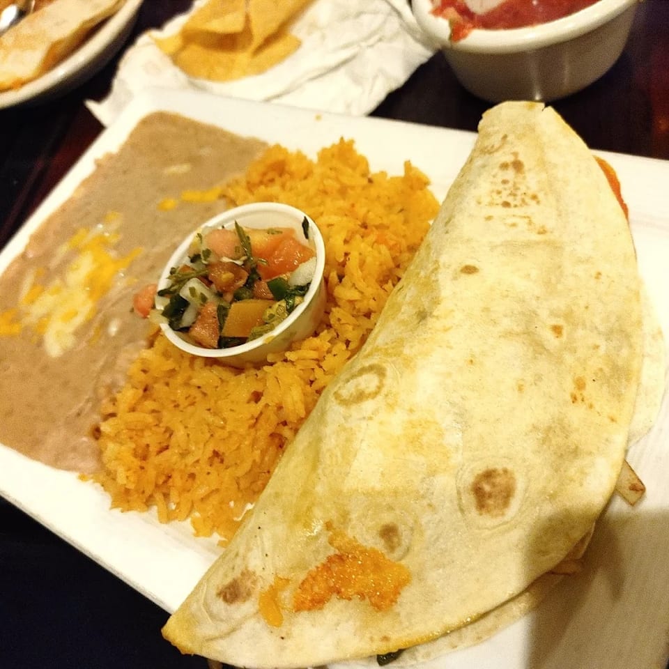 Lunch burrito served with rice and beans.